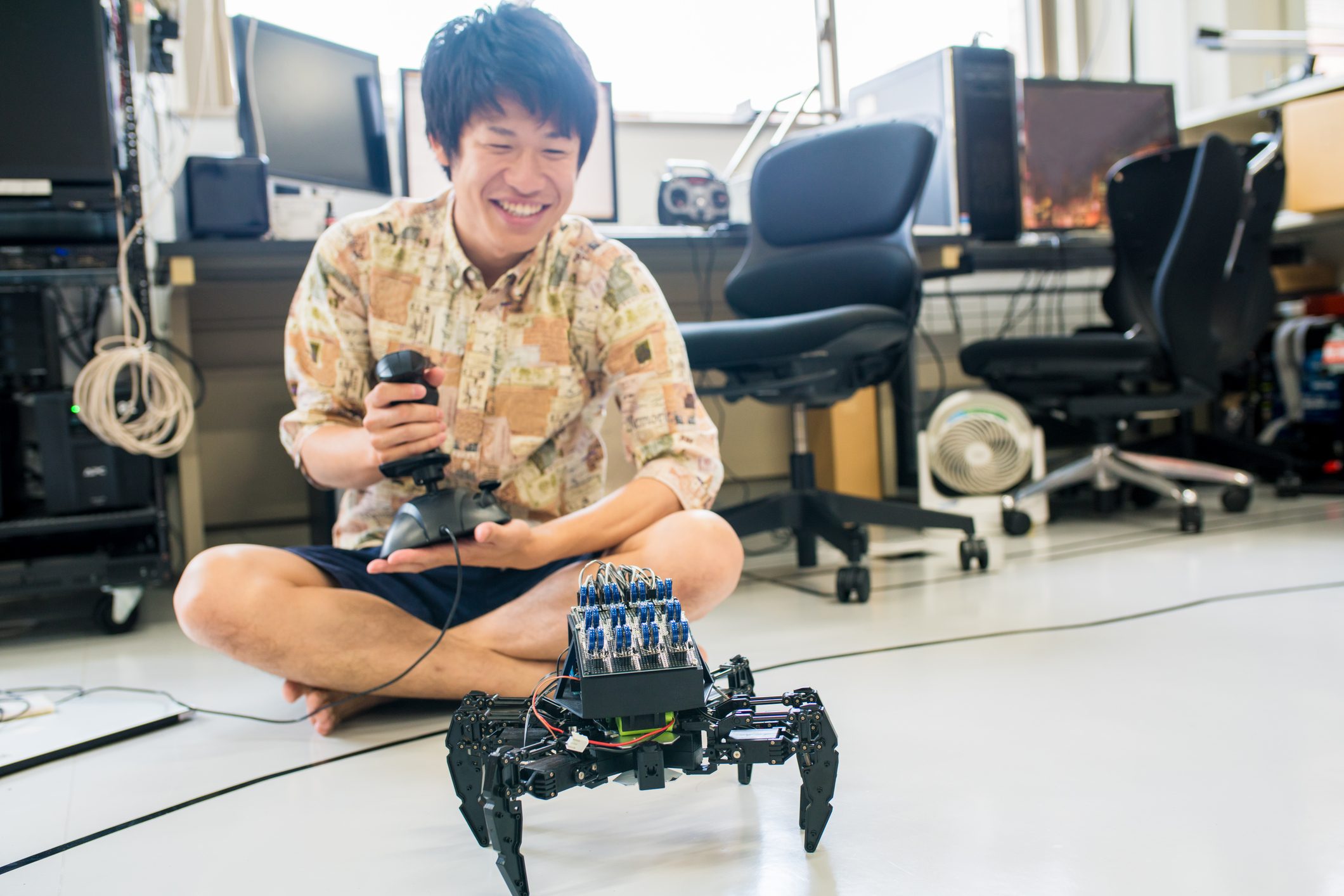 آي ستوك: طالب جامعي في مختبره باستخدام جهاز تحكم عن بعد لتحريك تصميمه الروبوتي. كيوتو في اليابان