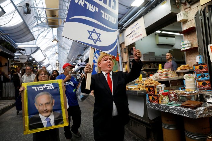 مؤيدوه حزب الليكود يرفعون صوراً لنتنياهو وترامب في القدس المحتلة خلال الحملة الانتخابية/ رويترز