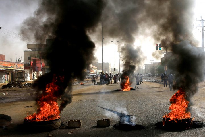 المتظاهرون السودانيون يستخدمون الإطارات المحترقة لإقامة حاجز في أحد الشوارع/رويترز