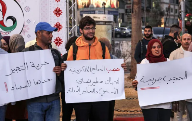 ناشطون فلسطينيون يرفعون لافتات تدعم حرية التعبير خلال مظاهرة في مدينة رام الله بالضفة الغربية ، 23 تشرين الأول (أكتوبر) 2019/ AFP