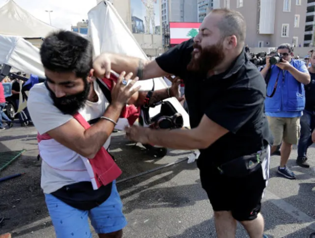 أحد مؤيدي حزب الله يعتدي على متظاهر مناهض للحكومة خلال الاحتجاجات المستمرة ضد الحكومة اللبنانية في بيروت ، لبنان ، 29 أكتوبر 2019/ AP