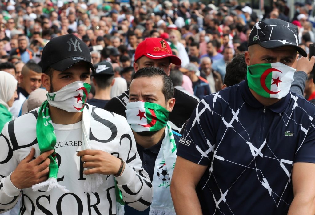 المتظاهرون يغطون وجوههم بالأعلام الوطنية خلال مظاهرة مناهضة للحكومة في الجزائر العاصمة ، الجزائر ، 13 مارس 2020. رويترز