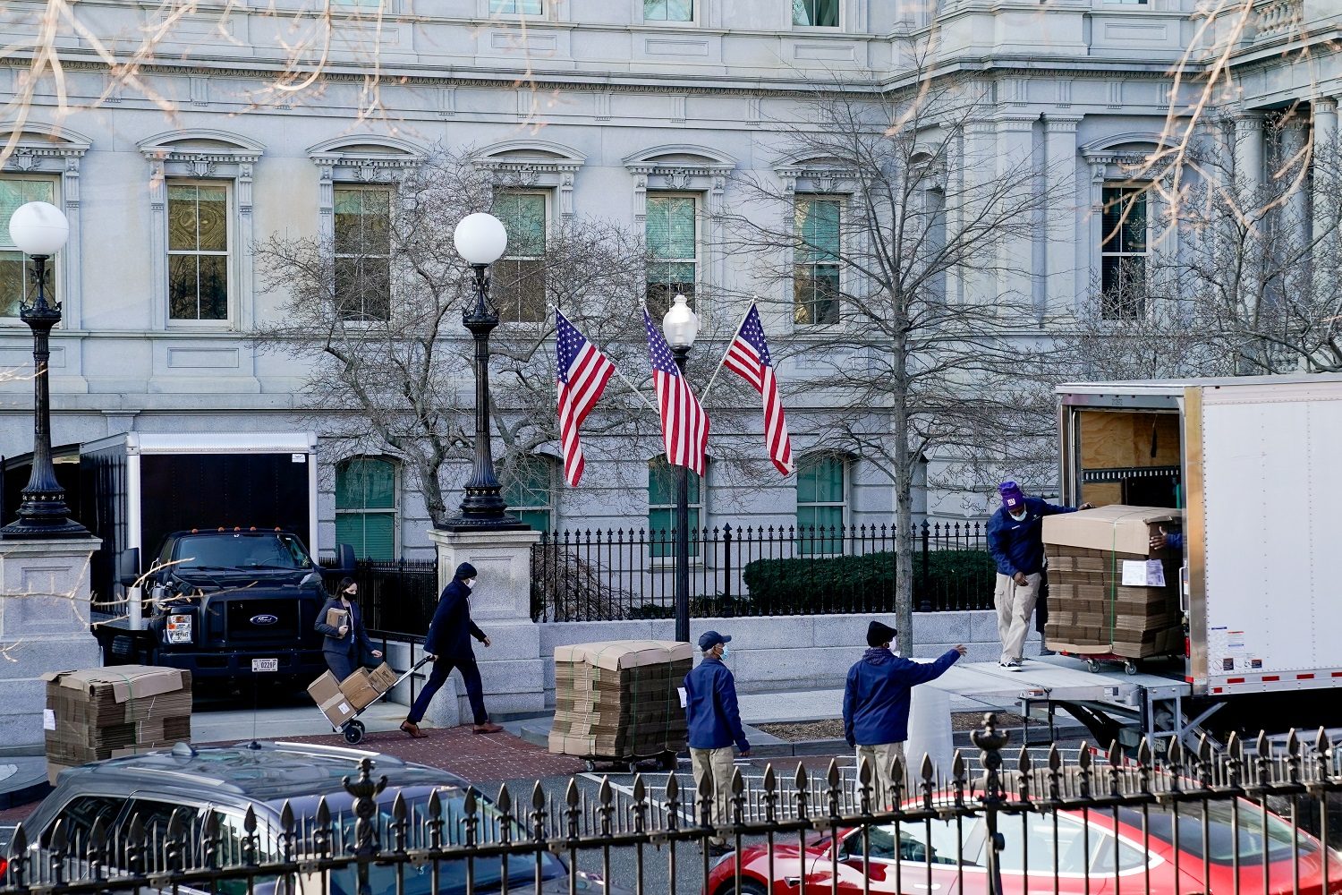 عُمال ينقلون صناديق كرتونية محملة بأغراض من البيت الأبيض/ رويترز