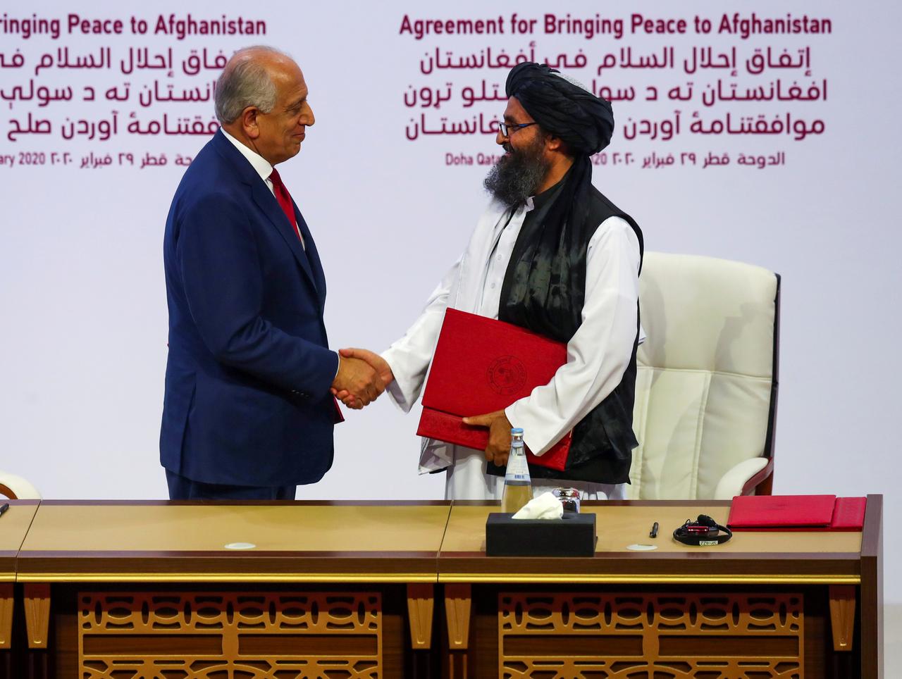 زلماي خليل زادة الممثل الأمريكي لأفغانستان مع رئيس وفد طالبان/ رويترز