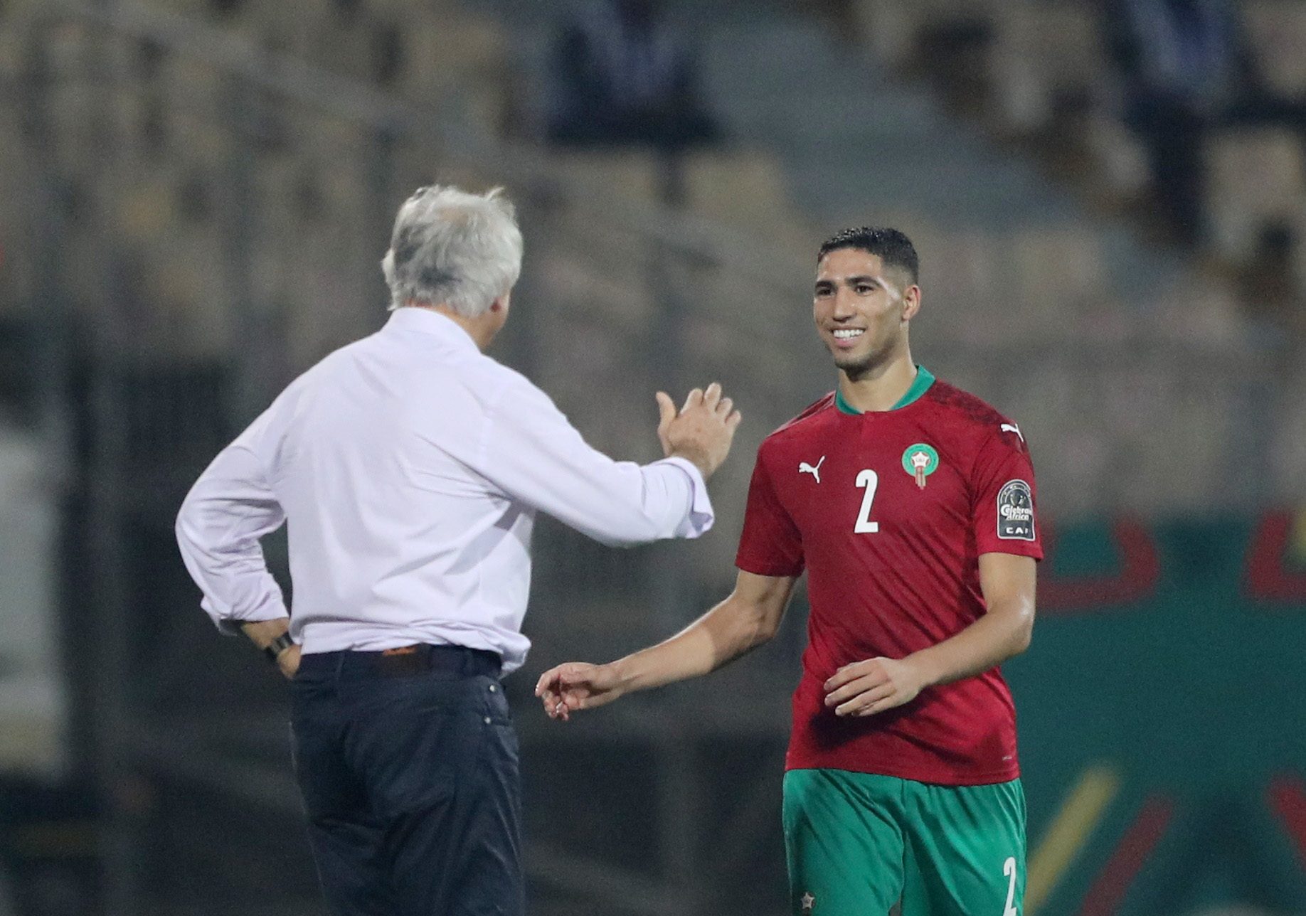 مدرب المنتخب المغربي رفقة اللاعب أشرف حكيمي (رويترز)