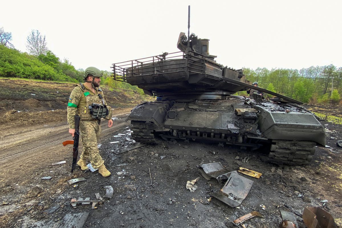 جندي أوكراني بجوار دبابة روسية محطمة من طراز تي 90/رويترز