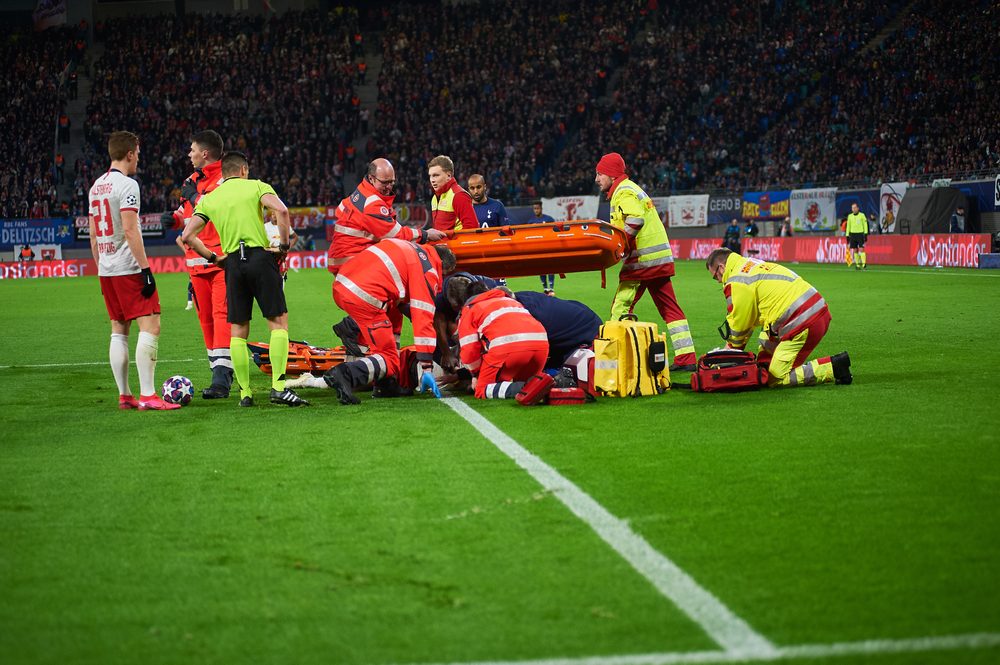 المسعفون يهرعون لنجدة لاعب في إحدى المباريات - Shutterstock