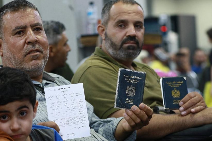 ركاب يحملون جوازات سفر فلسطينية يجلسون في غرفة انتظار على الجانب الأردني من جسر الملك حسين ، المعروف أيضًا باسم جسر اللنبي <br>