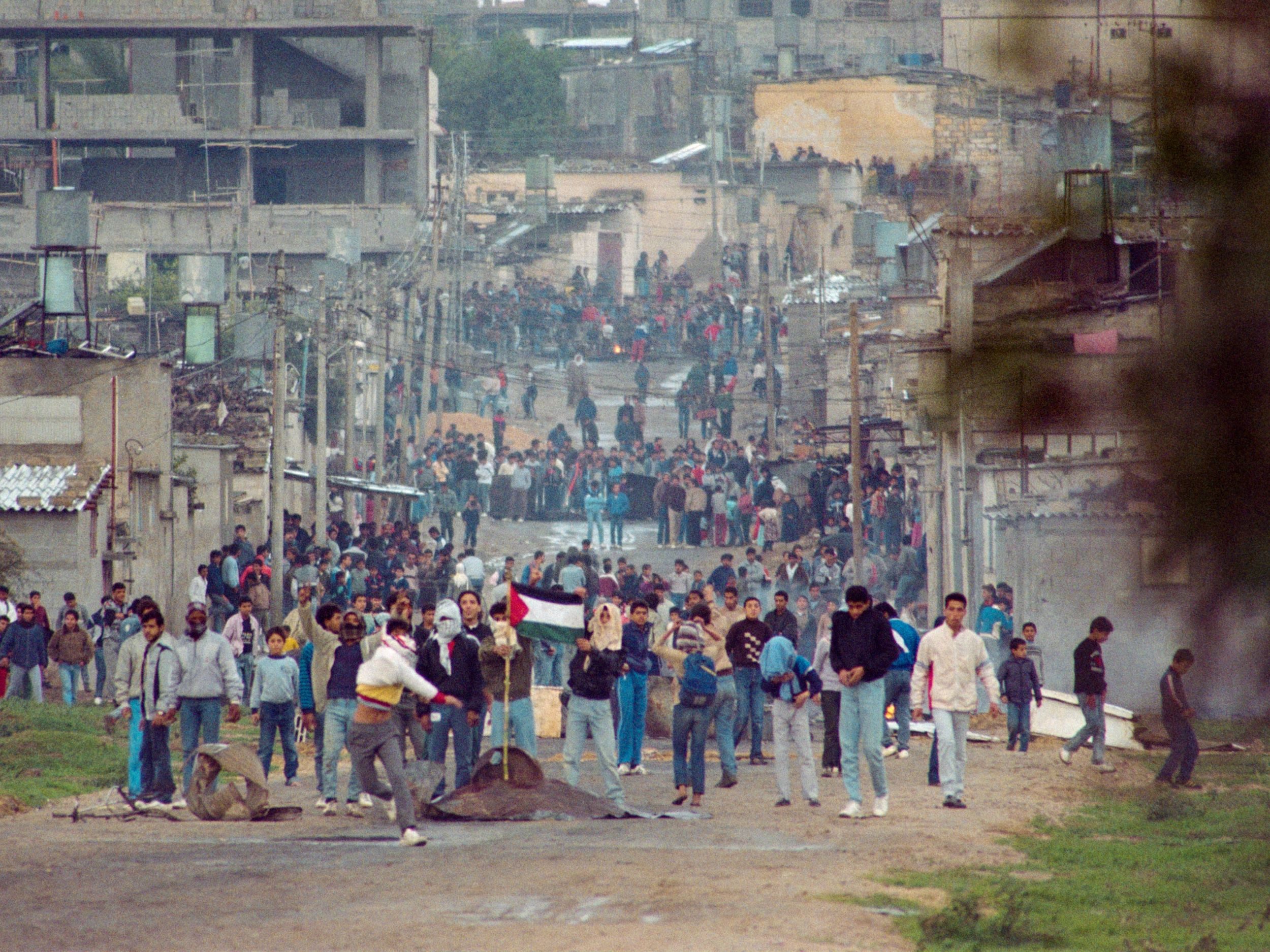شبان فلسطينيون يلقون الحجارة في مخيم جباليا شمال غزة، في 14 ديسمبر 1987، خلال الانتفاضة الأولى/ جيتي