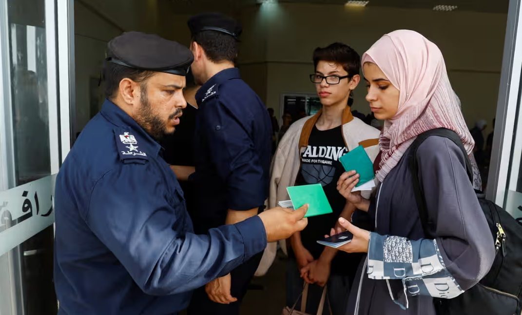 فلسطينيون يحملون جوازات سفر أجنبية ينتظرون الحصول على إذن لمغادرة غزة عند معبر رفح الحدودي/رويترز<br>